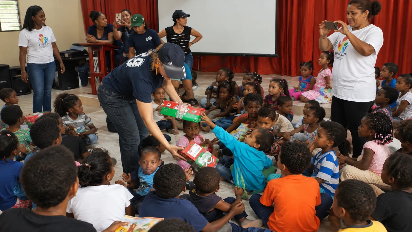 A PFHI volunteer sharing gifts with children at a community outreach